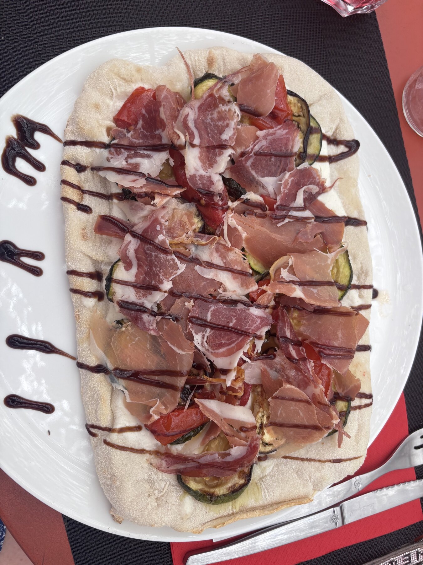 Pinsa garnie de charcuterie et de légumes servie chez Au P'tit Chênex