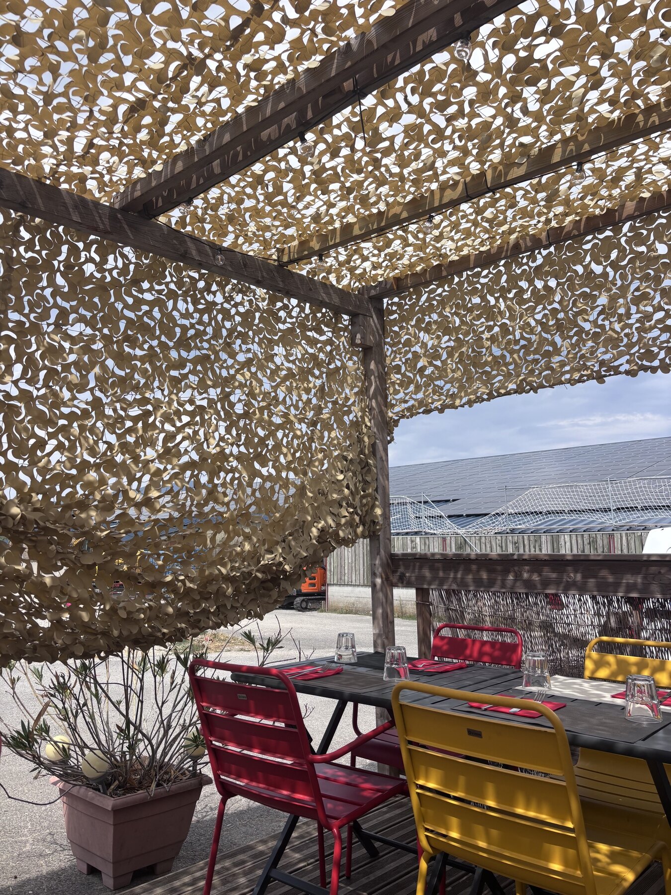 Terrasse ombragée du restaurant Au P'tit Chênex avec tables dressées à Chênex